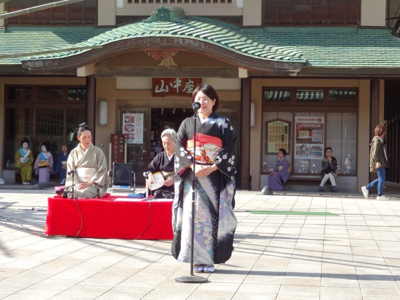 山中座の前で山中節を唄う様子
