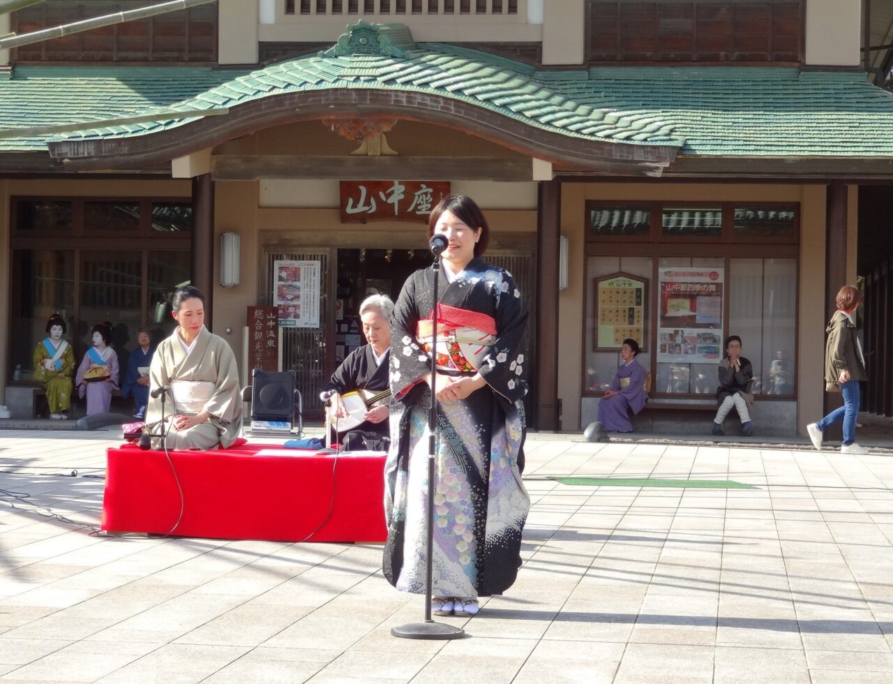 山中座の前で山中節を唄う様子